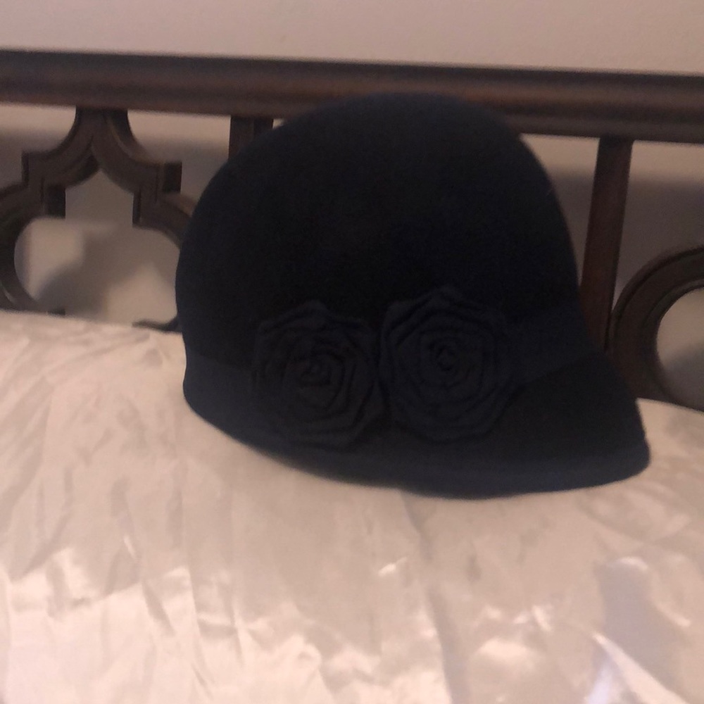 Cute little navy hat with one sided flower accent. 100% wool